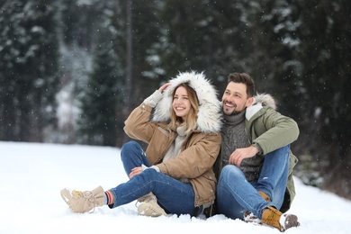 Couple spending time outdoors on snowy day. Winter vacation