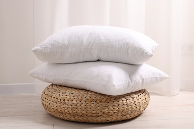 Photo of Soft pillows on wicker pouf in room