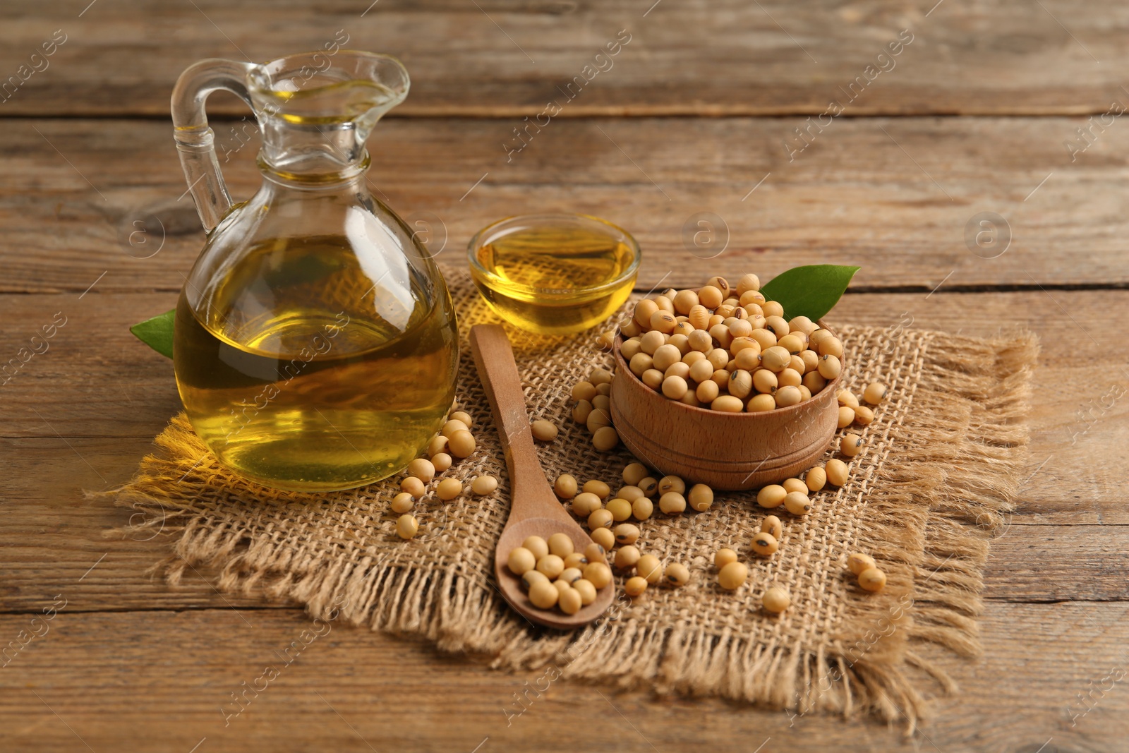 Photo of Composition with soybean oil on wooden table