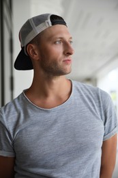 Photo of Portrait of handsome young man in stylish cap outdoors