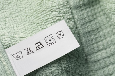 Clothing label on light green fluffy towel, top view