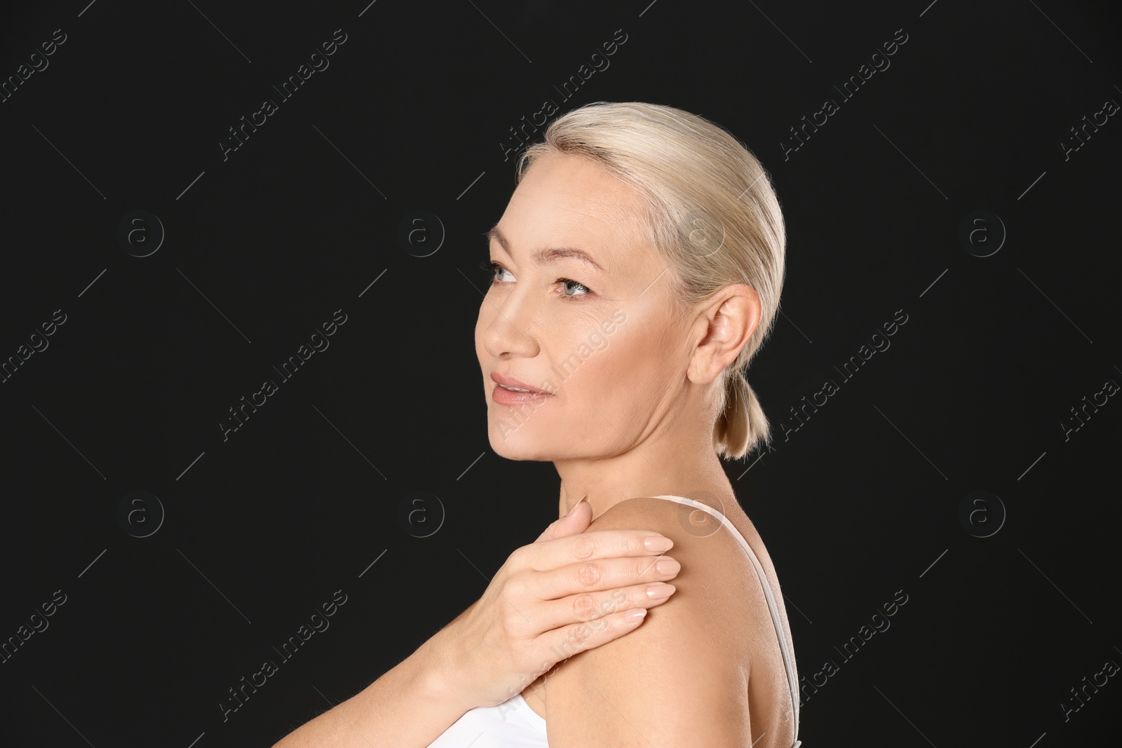 Photo of Portrait of beautiful mature woman on black background