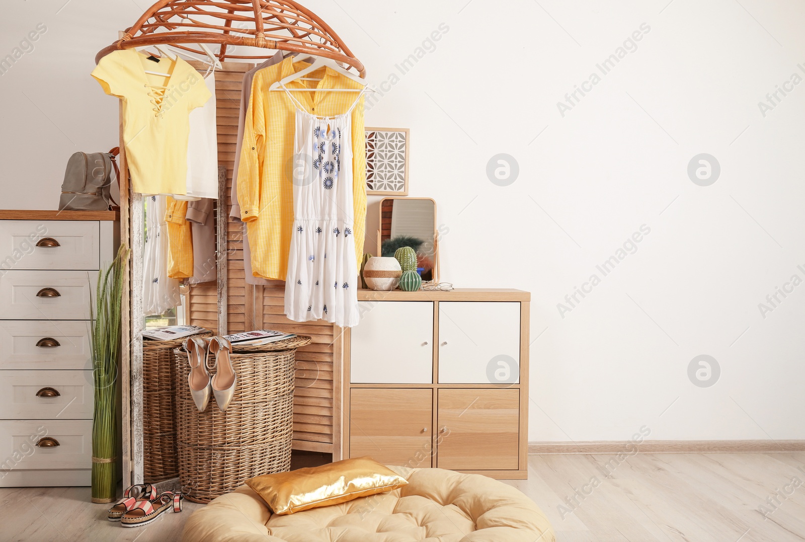 Photo of Stylish dressing room interior with wooden furniture and clothes