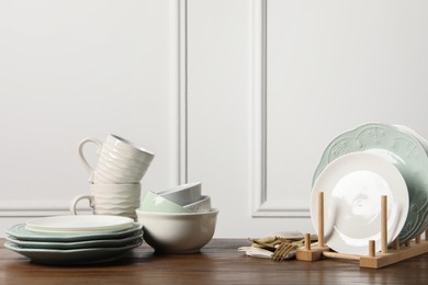 Beautiful ceramic dishware, cups and cutlery on wooden table