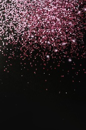 Photo of Rose gold glitter on black background, top view with space for text