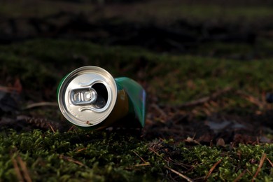 Photo of Used aluminum can on grass in forest, space for text. Recycling problem