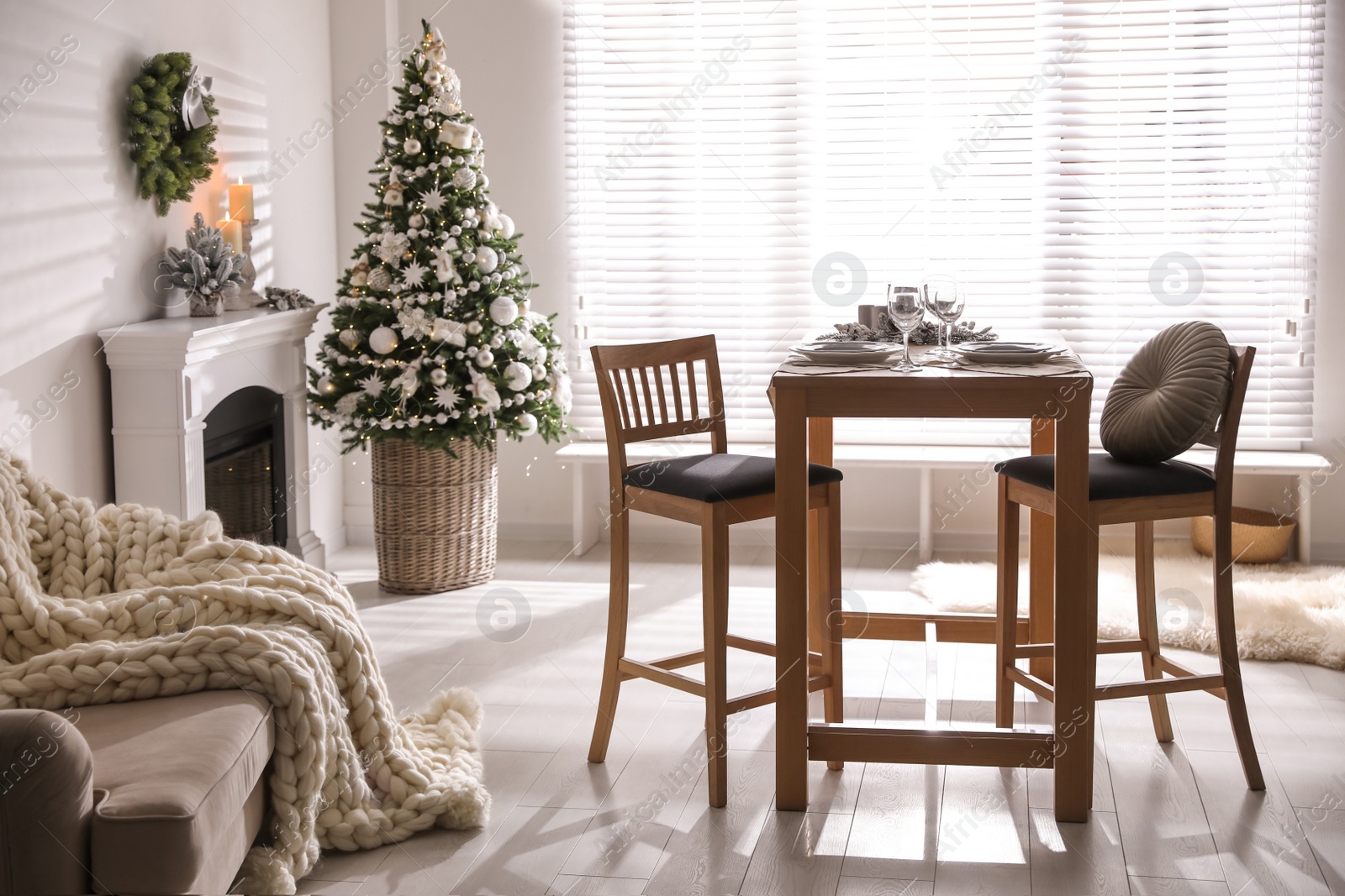 Photo of Festive table setting and beautiful Christmas decor in living room. Interior design