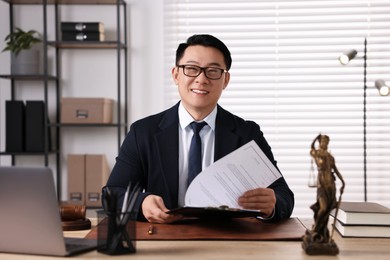 Happy notary working at wooden table in office