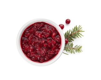 Photo of Bowl of cranberry sauce with fir tree branches on white background, top view