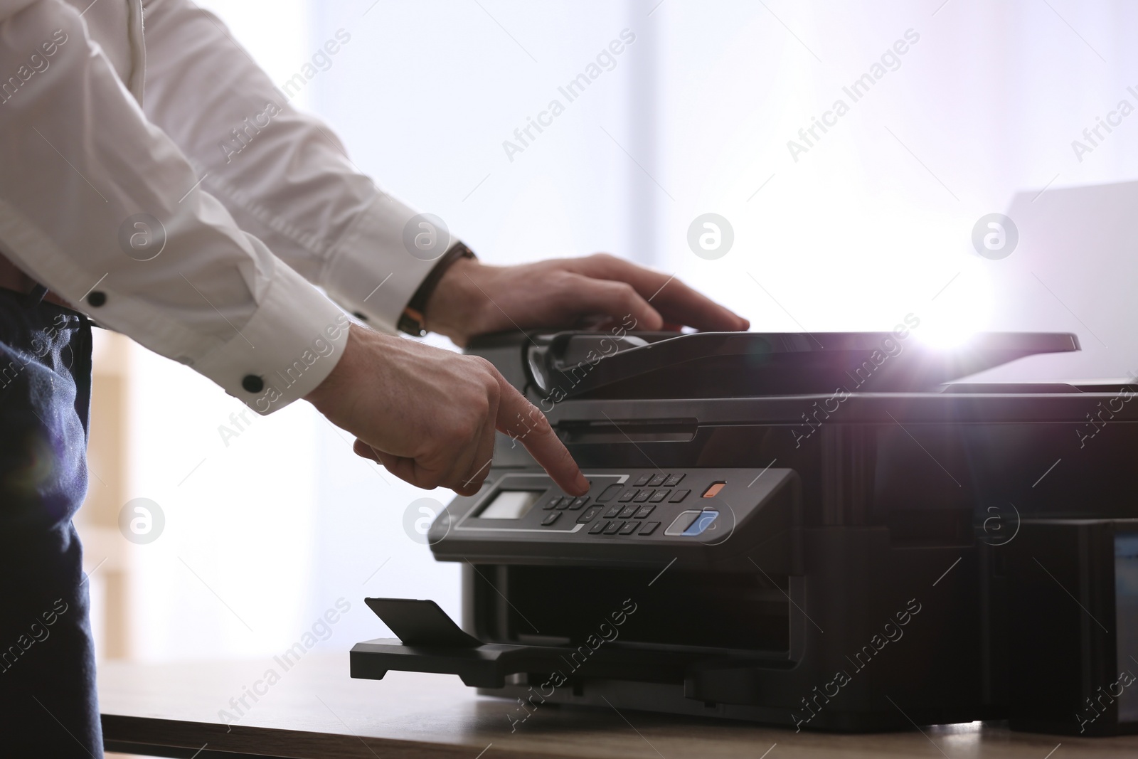 Photo of Employee using modern printer in office, closeup