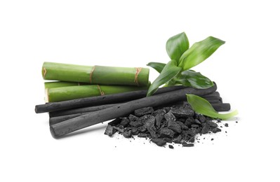 Photo of Fresh bamboo and charcoal on white background