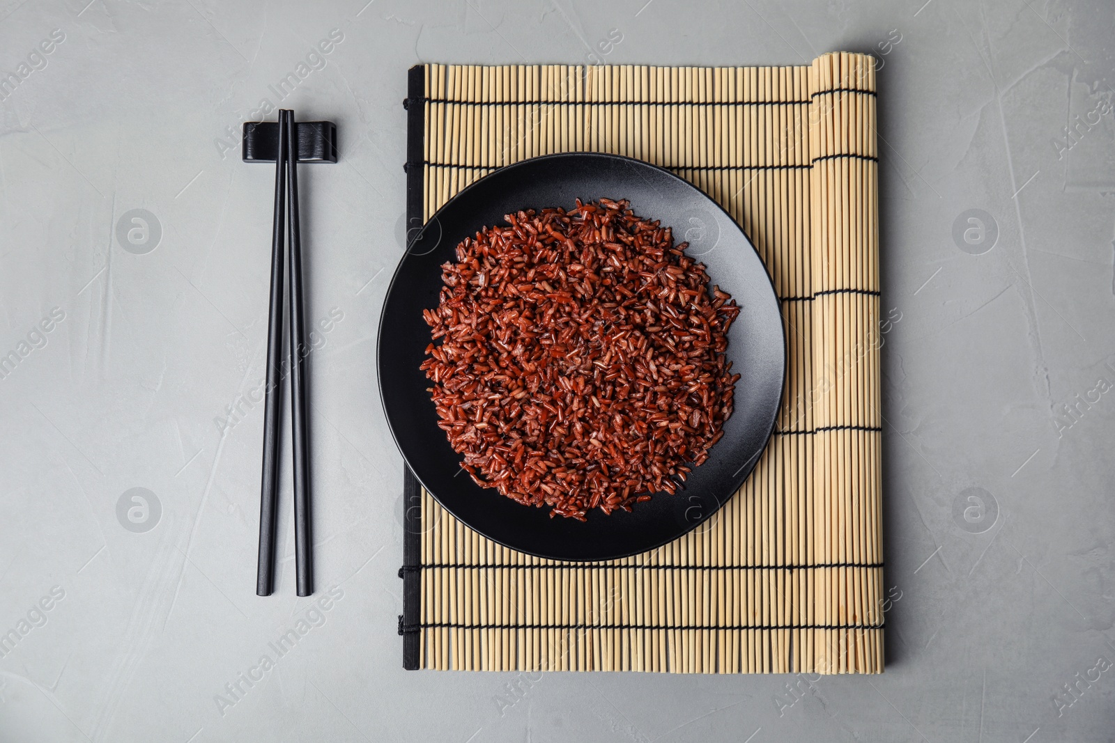 Photo of Flat lay composition with delicious cooked brown rice on table