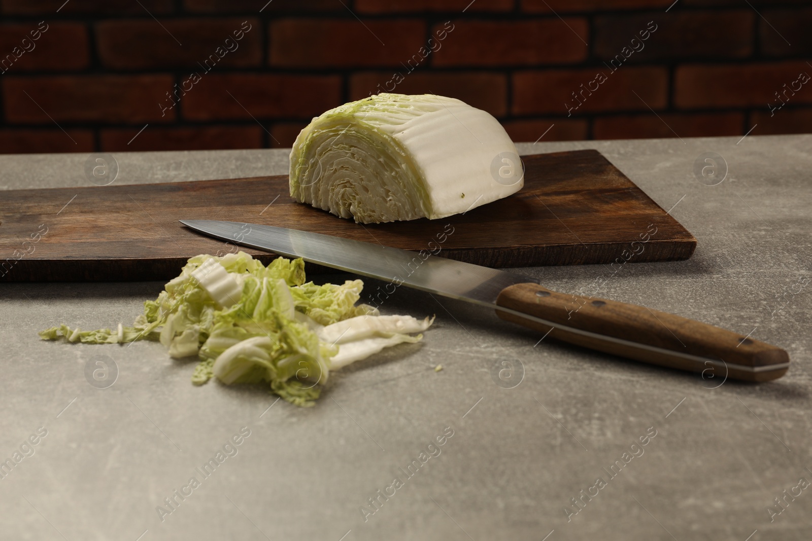 Photo of Cut fresh Chinese cabbage and knife on light grey table