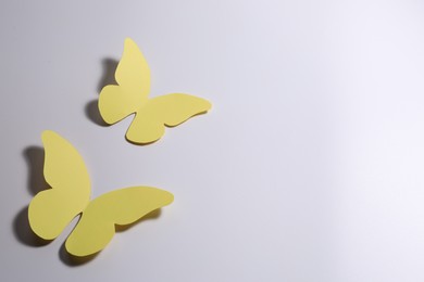 Yellow paper butterflies on light background. Space for text