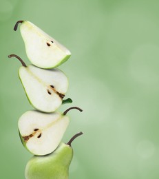 Image of Cut and whole fresh ripe pears on green background, space for text