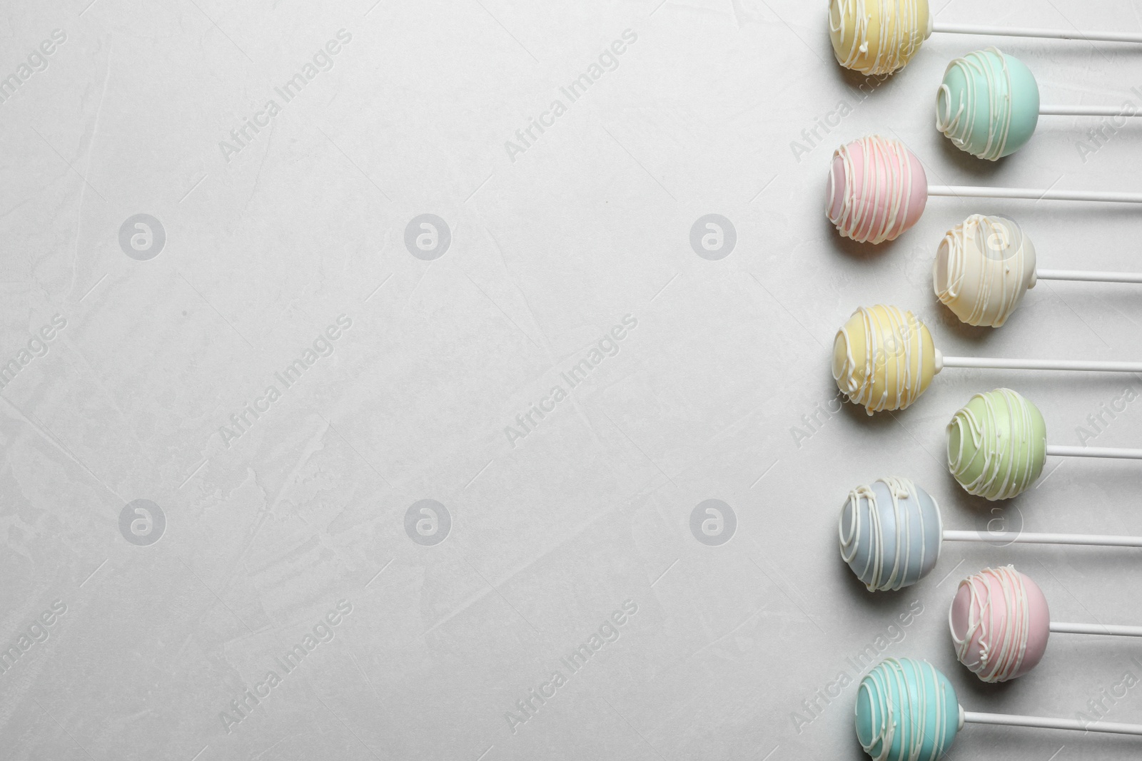 Photo of Sweet cake pops on light grey background, flat lay. Space for text