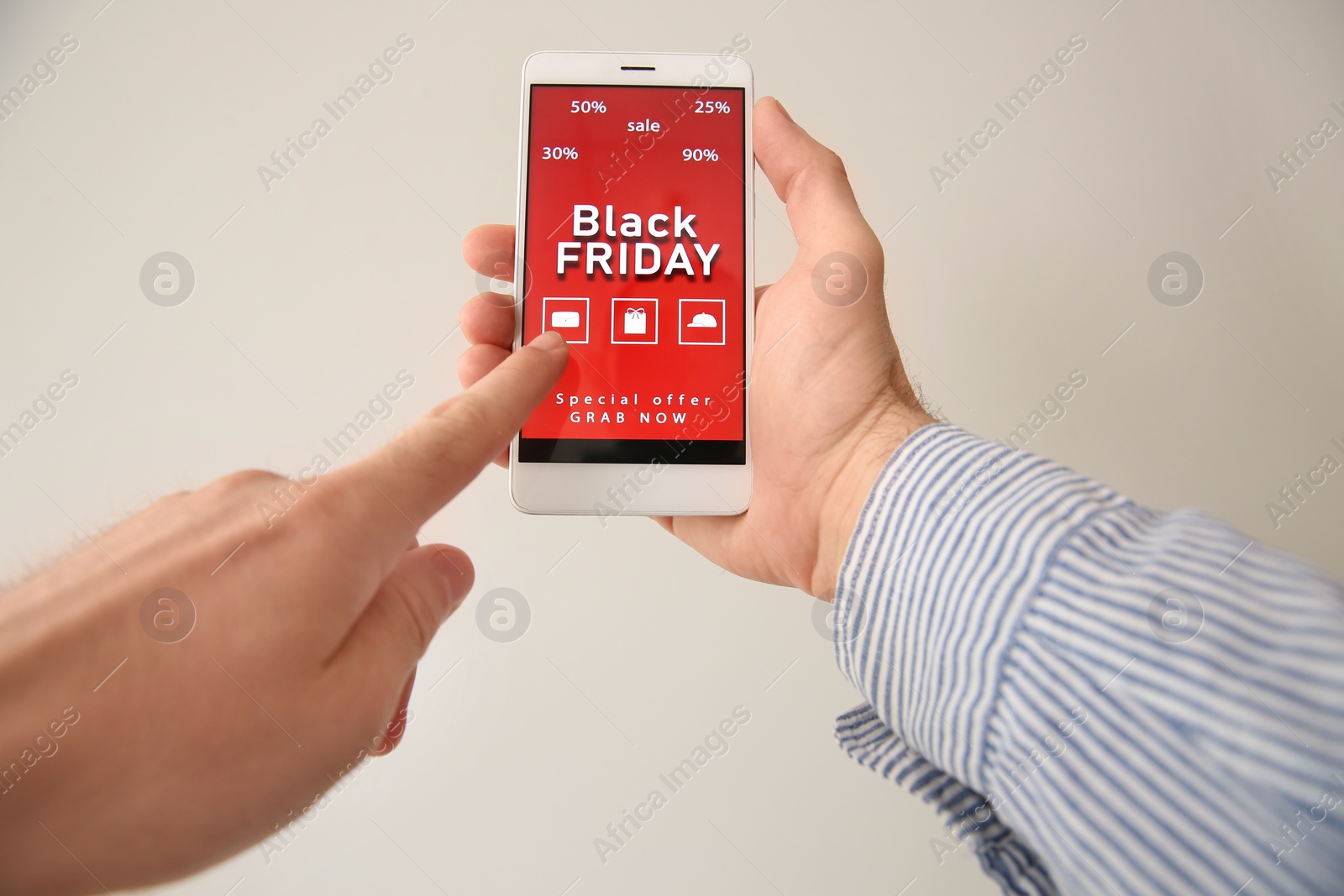 Photo of Man shopping online using smartphone on beige background, closeup. Black Friday Sale