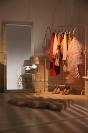 Photo of Modern dressing room interior with clothing rack and mirror