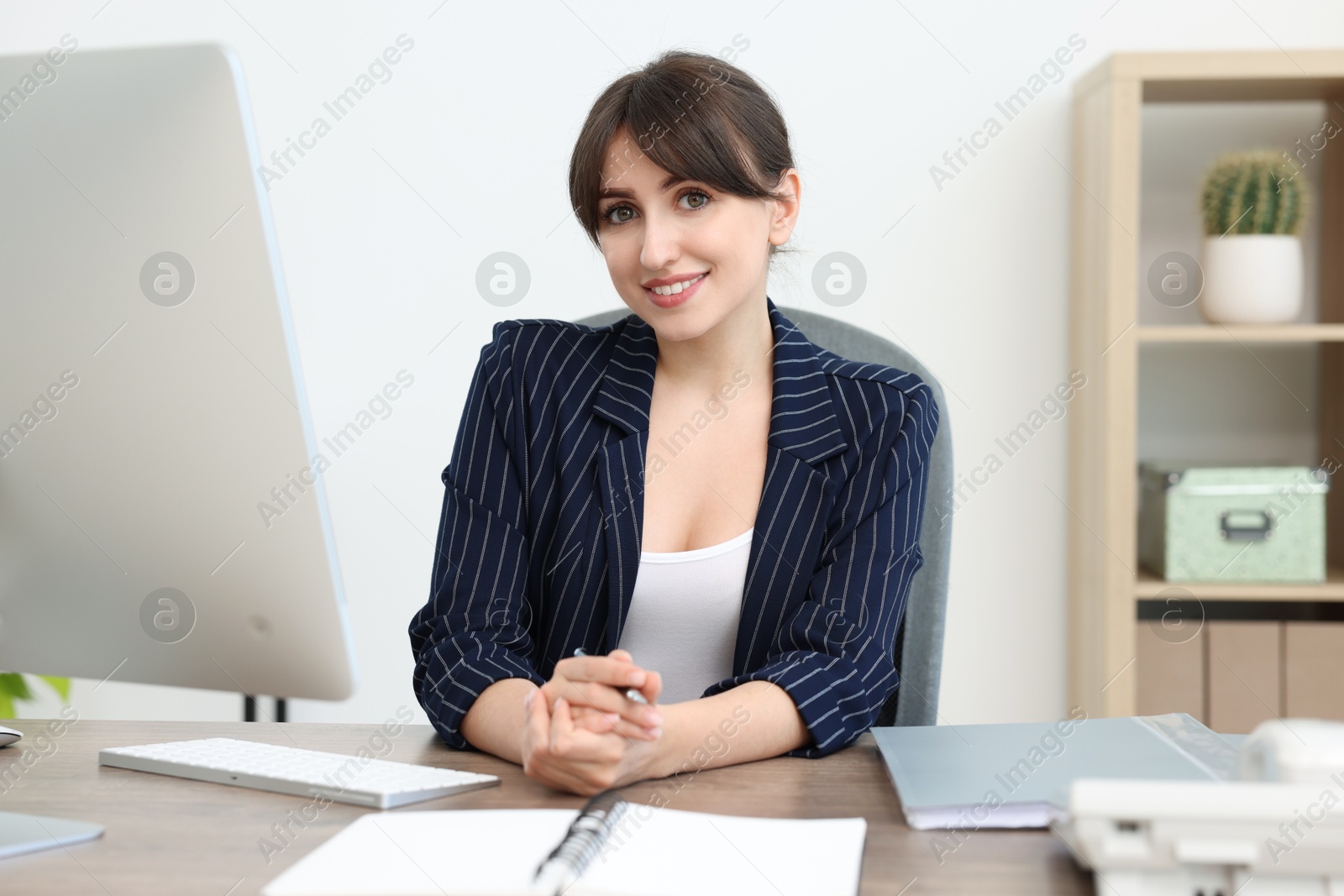 Photo of Portrait of smiling secretary at table in office