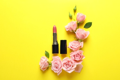 Photo of Flat lay composition with lipstick and roses on color background