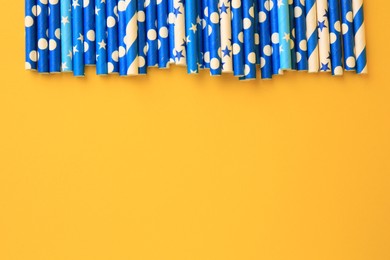 Photo of Many paper drinking straws on yellow background, flat lay. Space for text