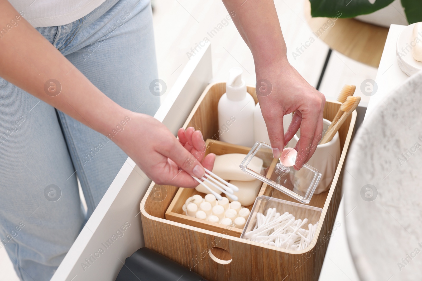 Photo of Bath accessories. Woman with cotton buds indoors, closeup