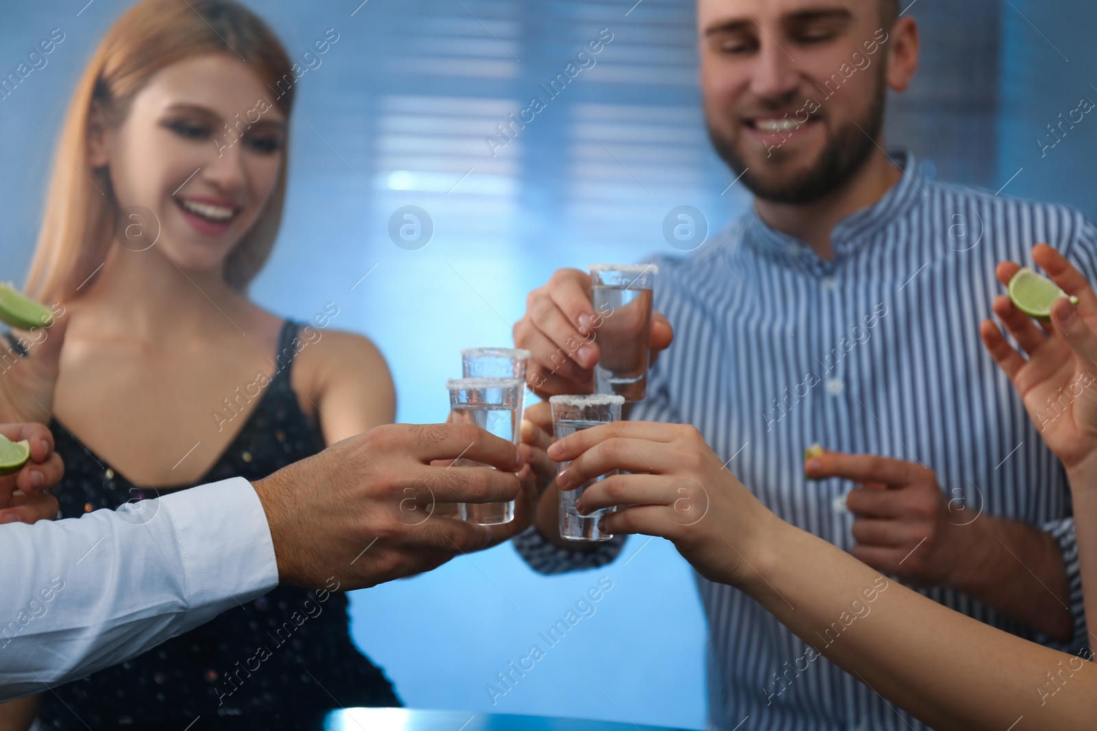Photo of Young people toasting with Mexican Tequila shots in bar