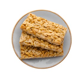 Photo of Plate with tasty peanut bars (kozinaki) isolated on white, top view