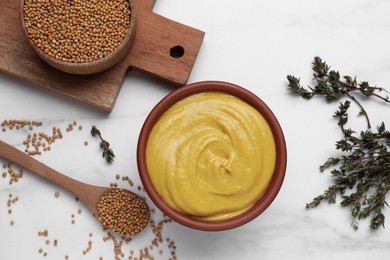 Photo of Bowl with delicious mustard, seeds and dry thyme on white marble table, flat lay