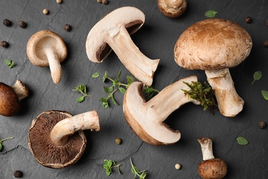 Flat lay composition with fresh wild mushrooms on black table