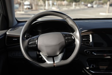Photo of Black steering wheel and dashboard in modern car