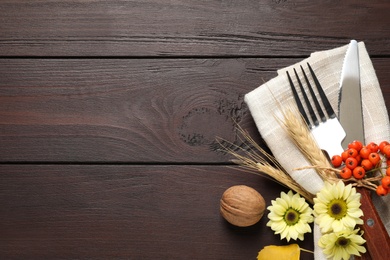 Cutlery with autumn decor and space for text on wooden table, flat lay. Thanksgiving Day celebration