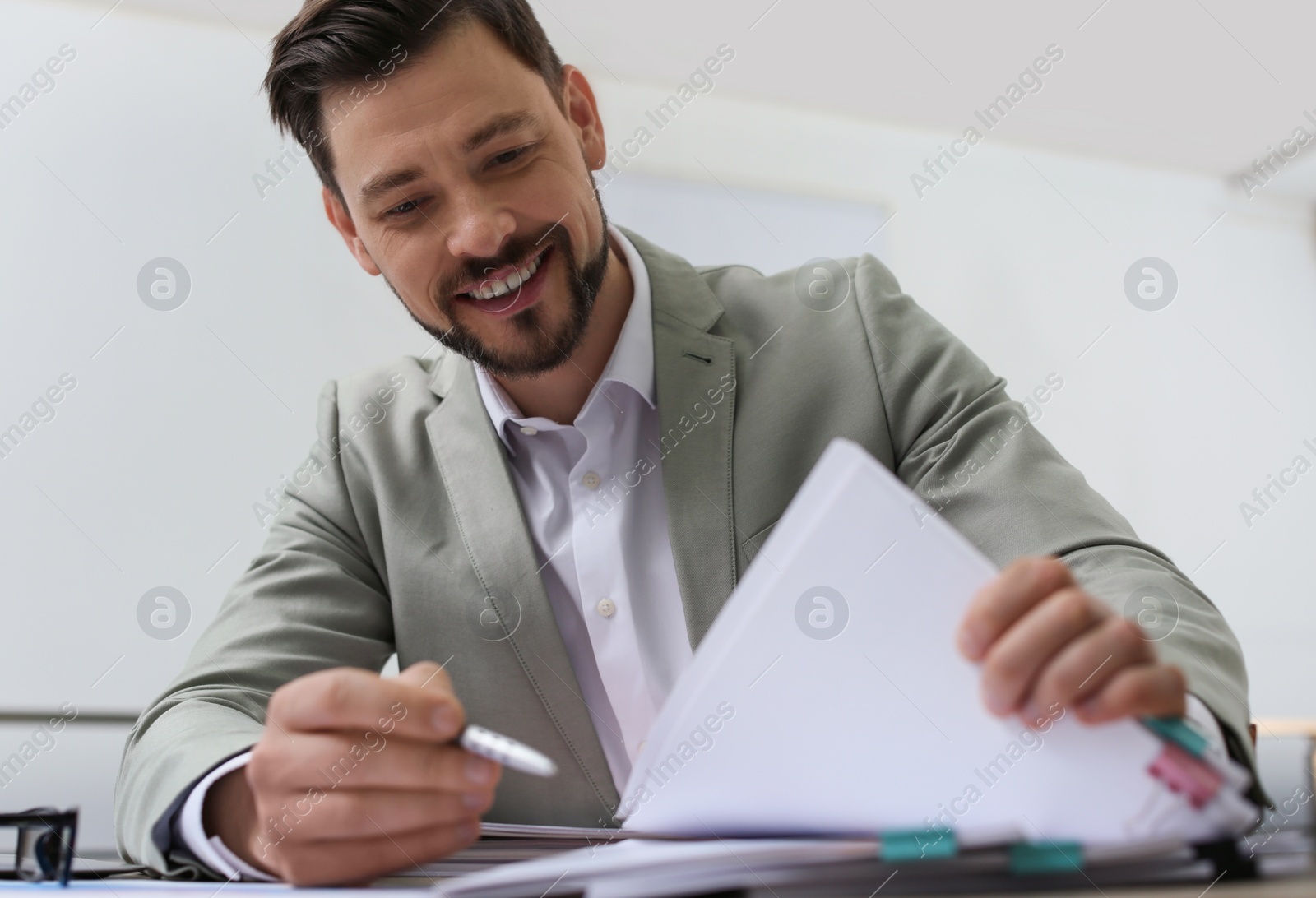 Photo of Businessman working with documents at table in office