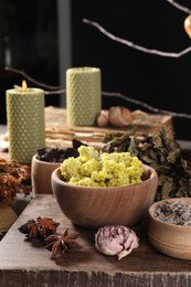 Many different dry herbs, flowers and candles on table