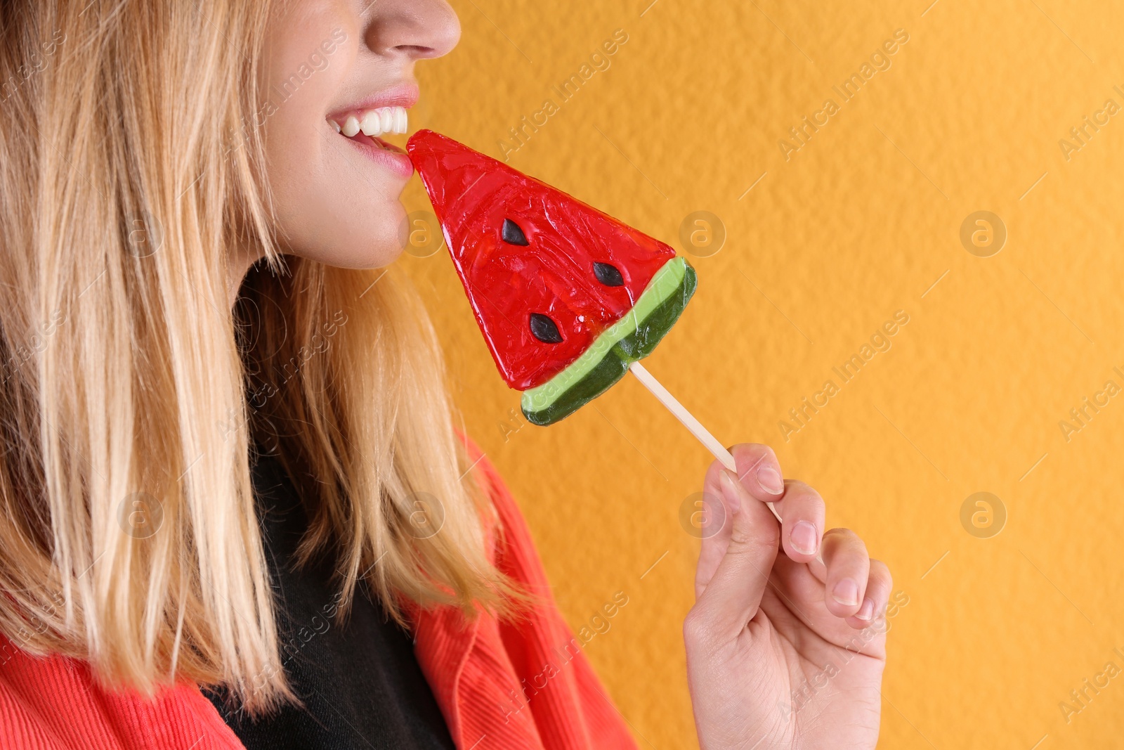 Photo of Young pretty woman with candy on colorful background, closeup