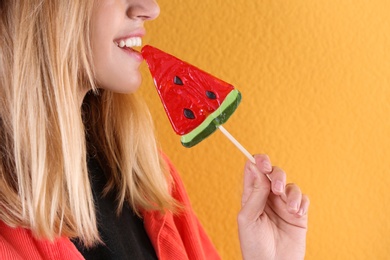 Young pretty woman with candy on colorful background, closeup