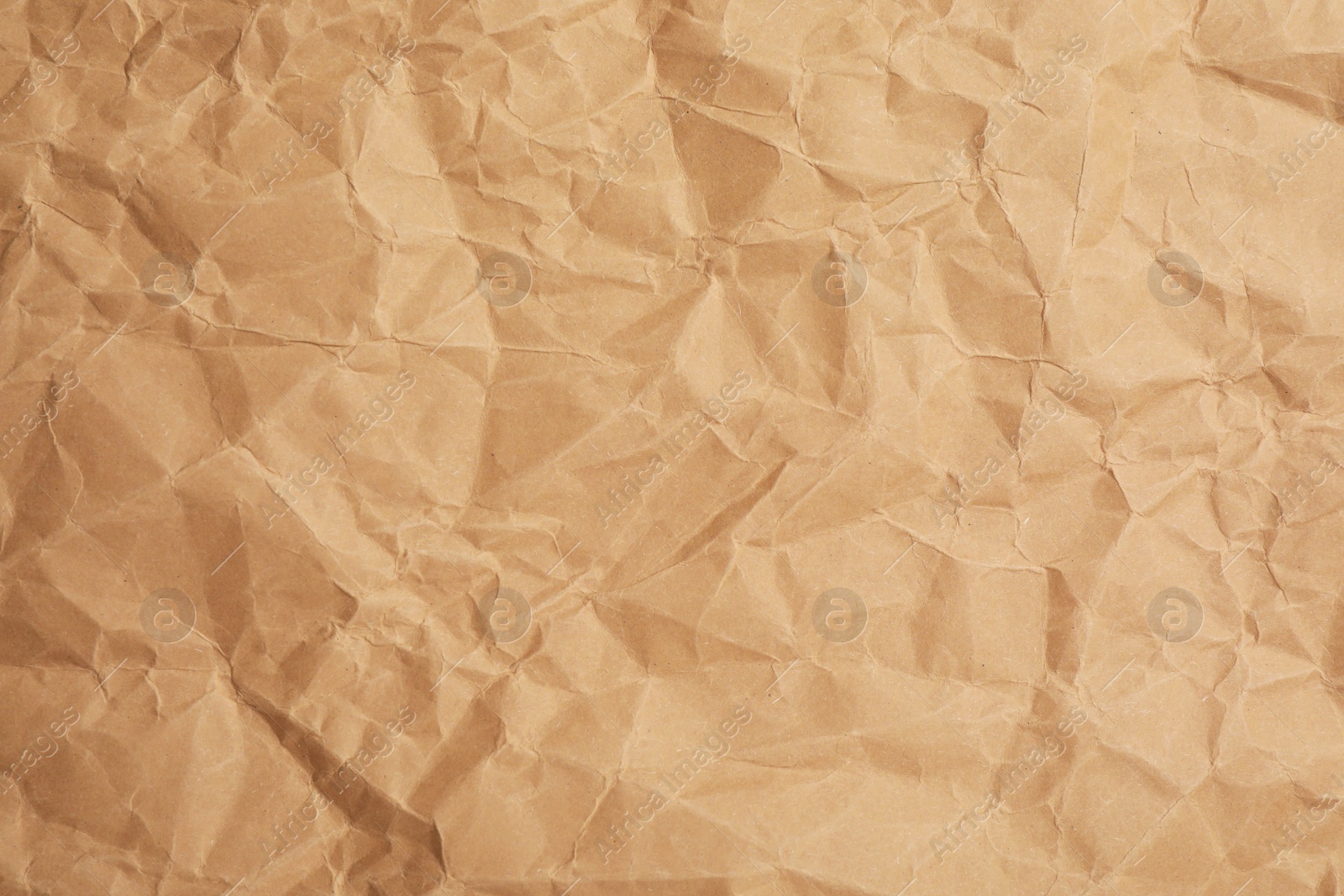 Photo of Texture of brown crumpled paper as background, closeup