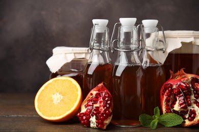 Tasty kombucha, mint and fresh fruits on wooden table