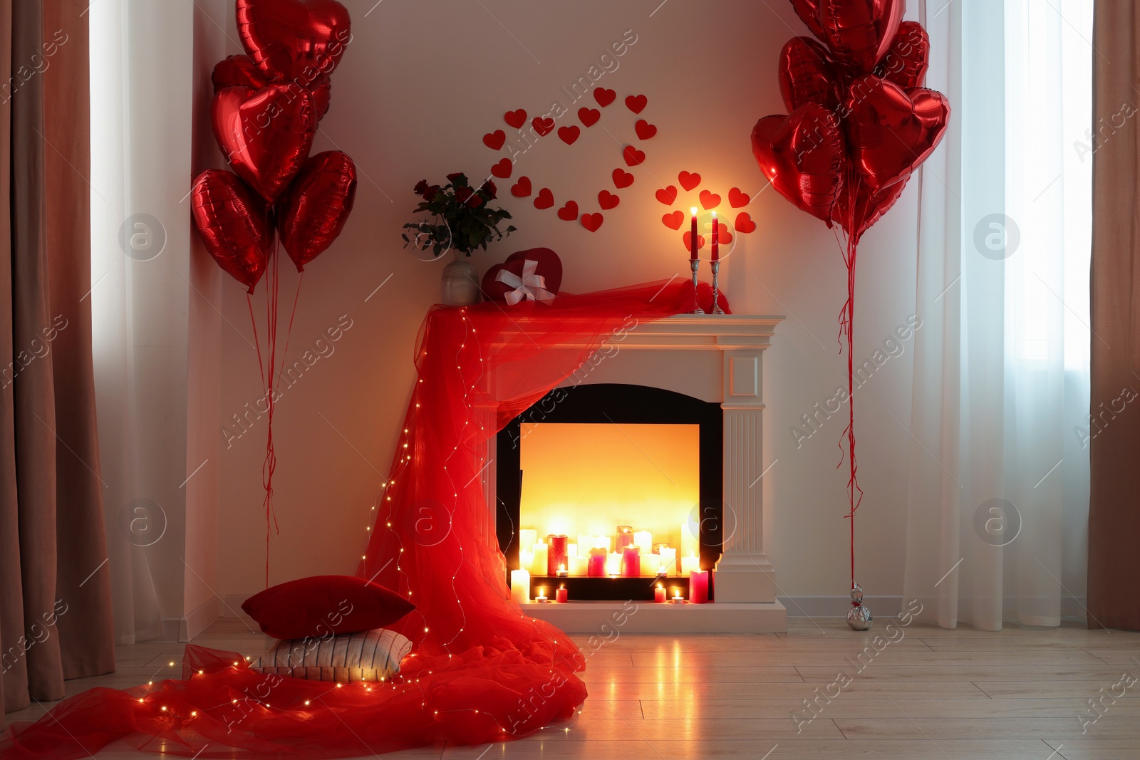 Photo of Stylish room with fireplace and Valentine's day decor. Interior design