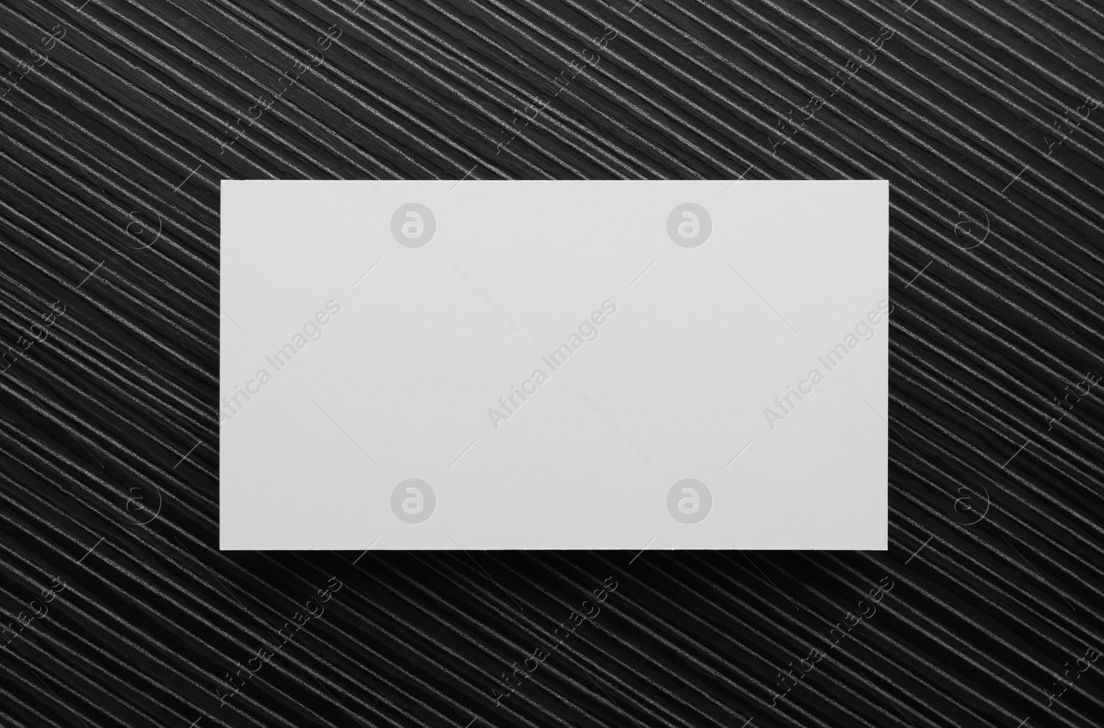 Photo of Blank business card on black wooden table, top view. Mockup for design