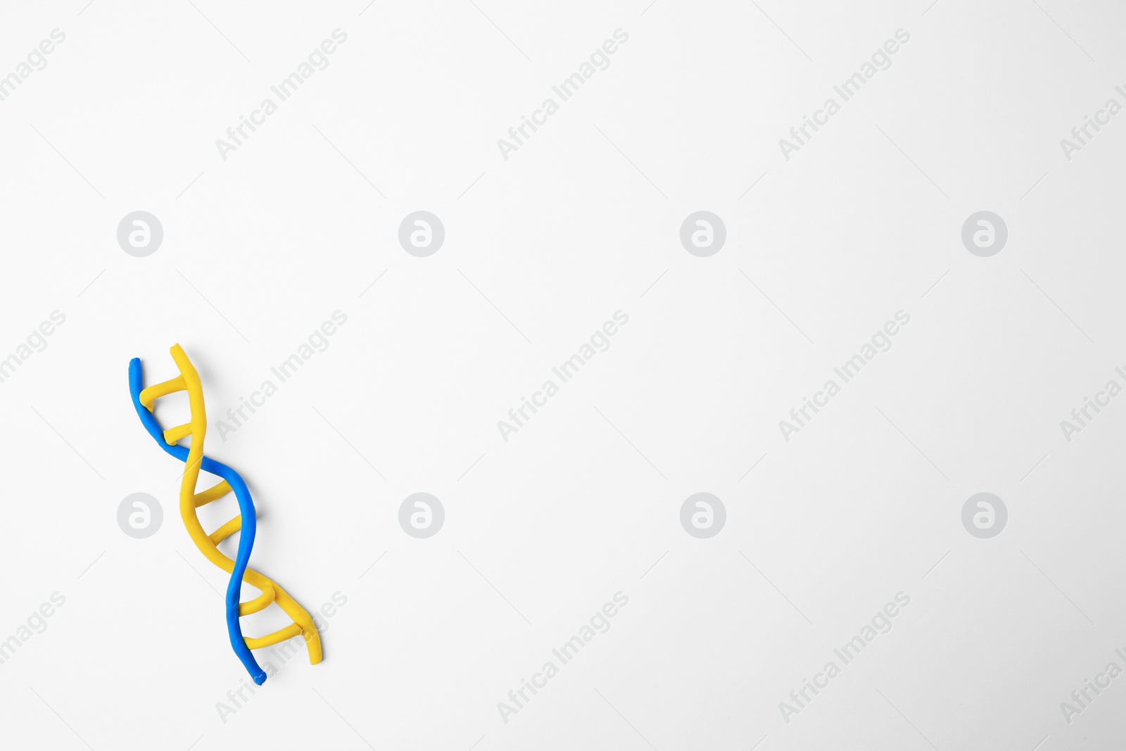 Photo of DNA molecule model made of colorful plasticine on white background, top view. Space for text