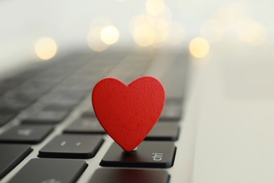 Photo of Decorative heart on laptop keyboard, closeup. Online dating concept