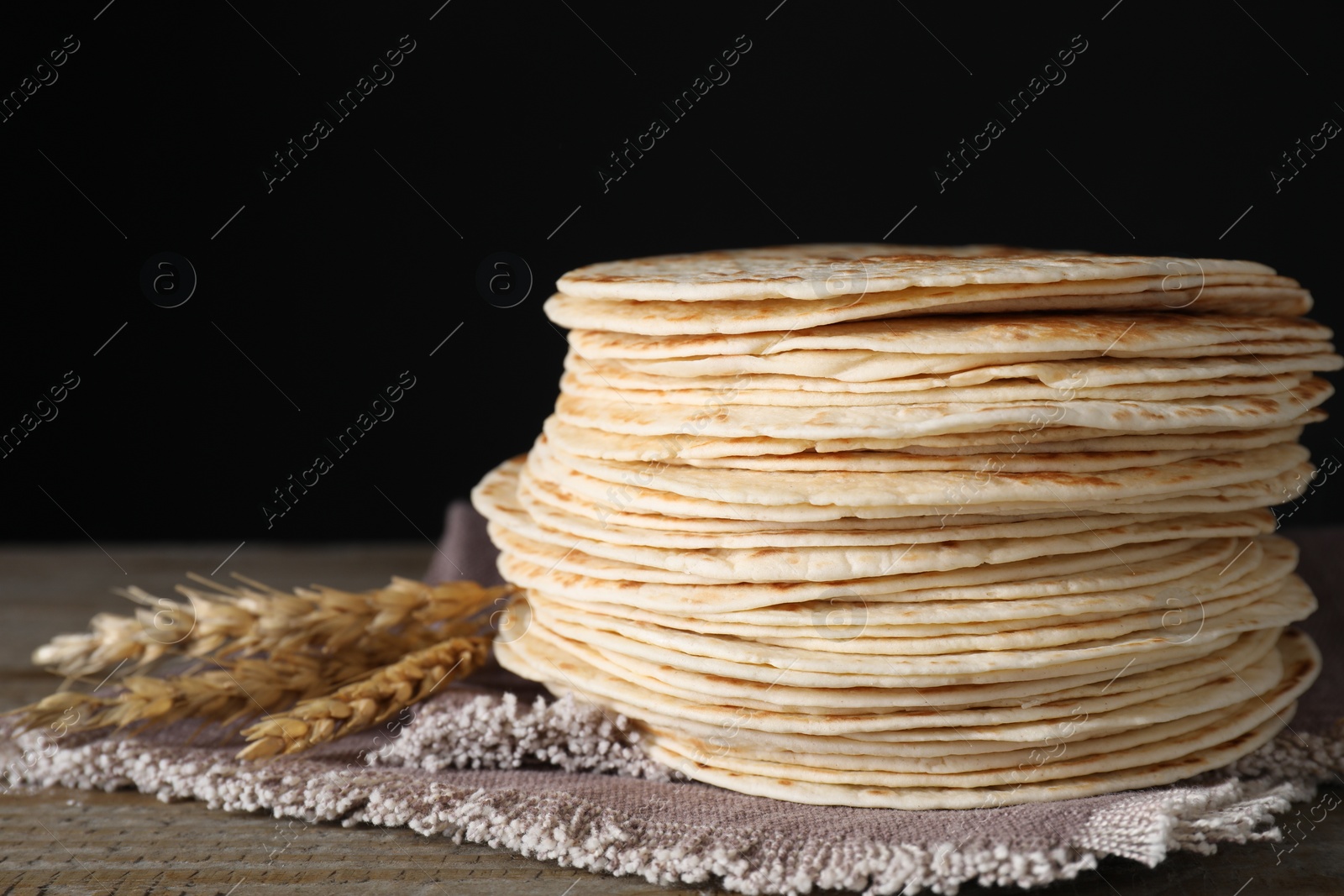 Photo of Many tasty homemade tortillas on wooden table, closeup