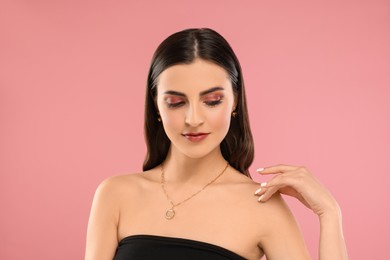 Photo of Beautiful woman with elegant necklace on pink background