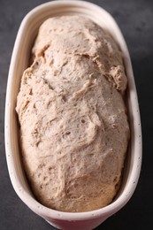 Photo of Fresh sourdough in proofing basket on grey table