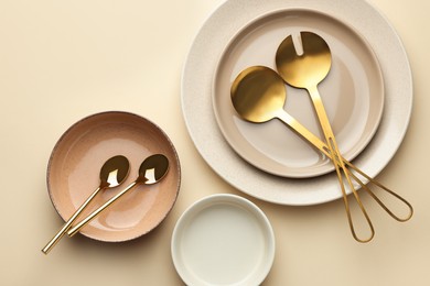 Photo of Stylish empty dishware and cutlery on beige background, flat lay