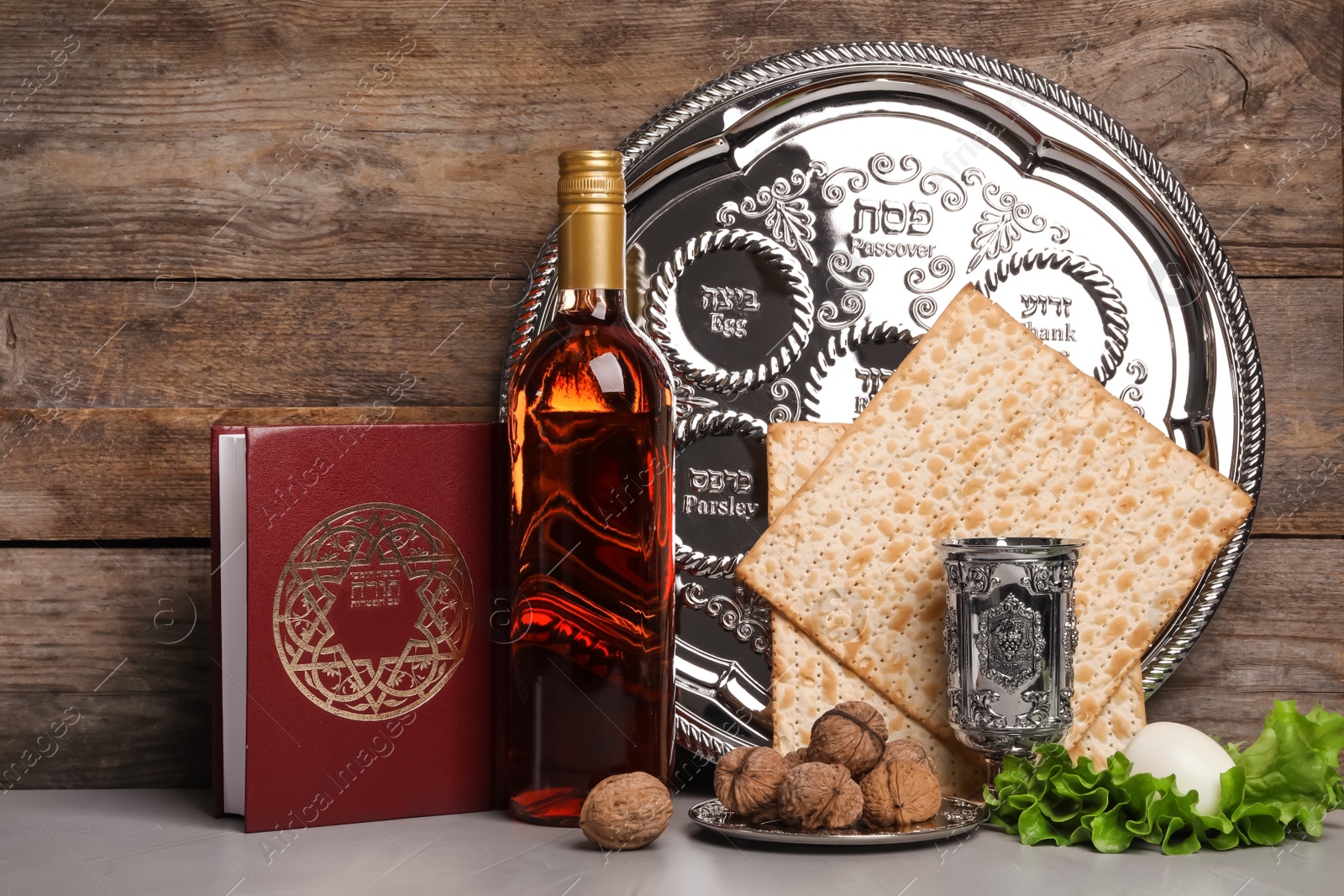 Photo of Symbolic Passover (Pesach) items on table against wooden background