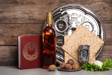 Photo of Symbolic Passover (Pesach) items on table against wooden background