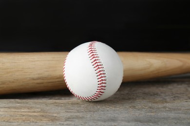 Photo of Baseball ball and bat on wooden table. Sports equipment