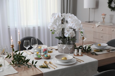 Beautiful Easter table setting with orchid flowers indoors